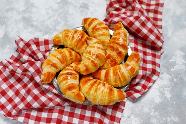 Frische leckere hausgemachte Croissants auf grau-weiß. französisches Gebäck