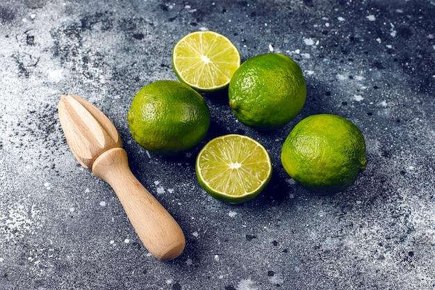 Frische Limetten mit hölzernem Zitruspresse, Draufsicht