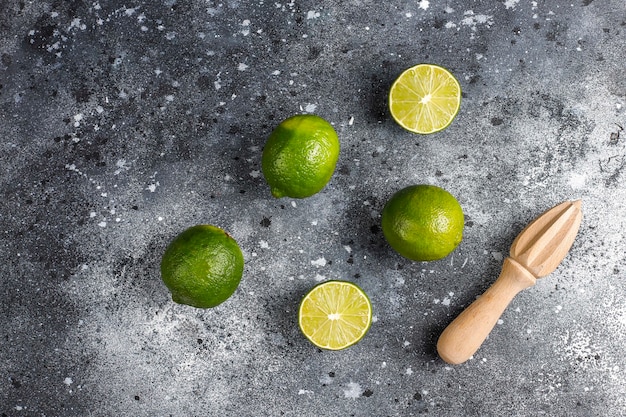 Frische Limetten mit hölzernem Zitruspresse, Draufsicht