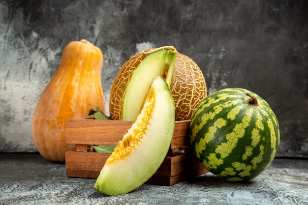 Frische Melone der Vorderansicht mit Kürbis und Wassermelone auf dem dunklen Hintergrund