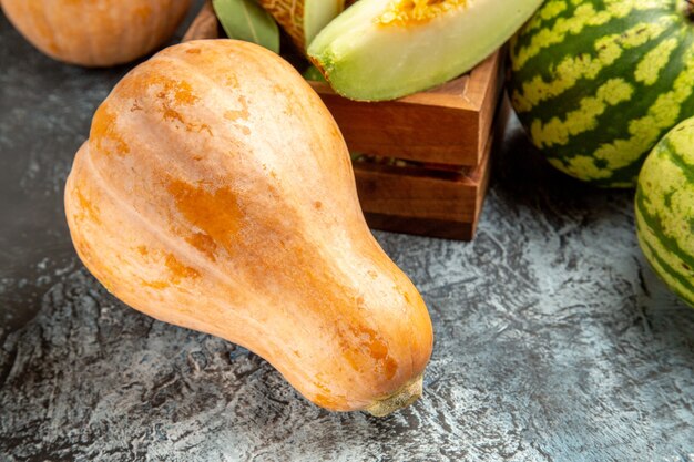 Frische Melone der Vorderansicht mit Kürbis und Wassermelone auf süßer Sommerfrucht des dunklen Bodens