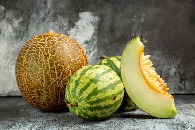 Frische Melone der Vorderansicht mit Wassermelone auf dunklem hellem Boden