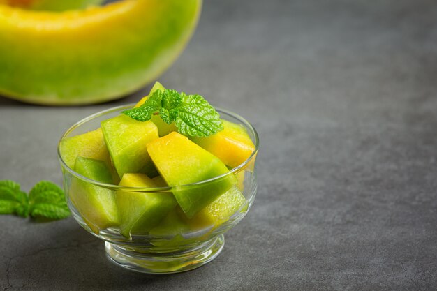 Frische Melone, in Stücke geschnitten, in eine Glasschüssel geben