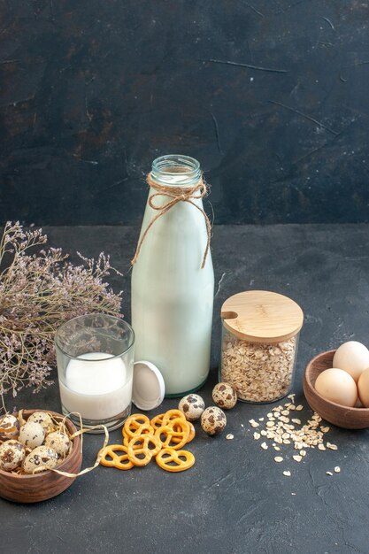 Frische Milch der Vorderansicht mit Honig und Eiern auf grauem Hintergrund Roher Frühstückskuchen der Milchfarbtorte