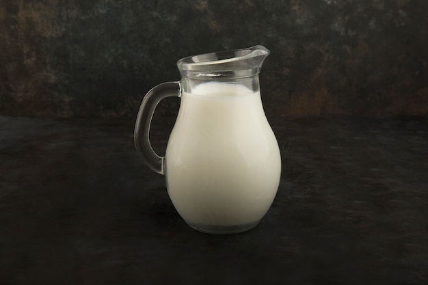 Frische Milch in einem Glas auf schwarzem Hintergrund