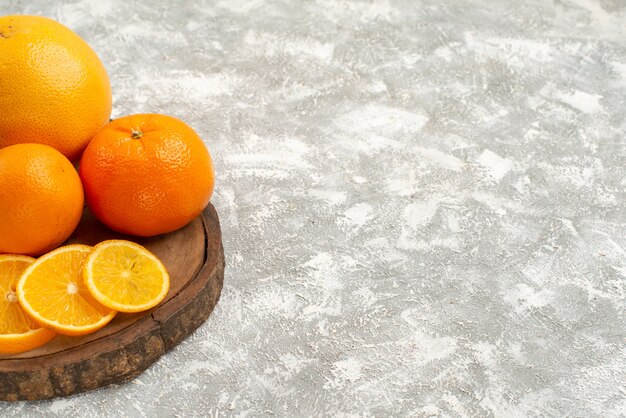 Frische Orangen der Vorderansicht mit Mandarinen auf reifen exotischen tropischen frischen Früchten des weißen Hintergrundzitrusfruchtes