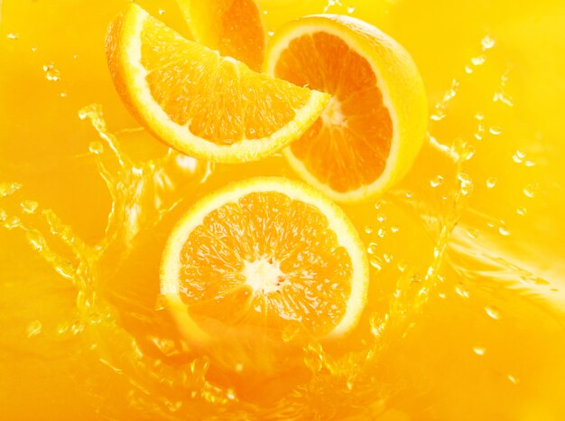 Frische Orangen fallen in Saft