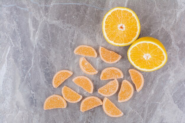 Frische Orangenscheiben mit süßen Marmeladen auf Marmorhintergrund.
