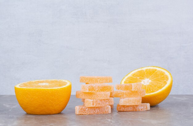 Frische Orangenscheiben mit süßen Marmeladen auf Marmorhintergrund.