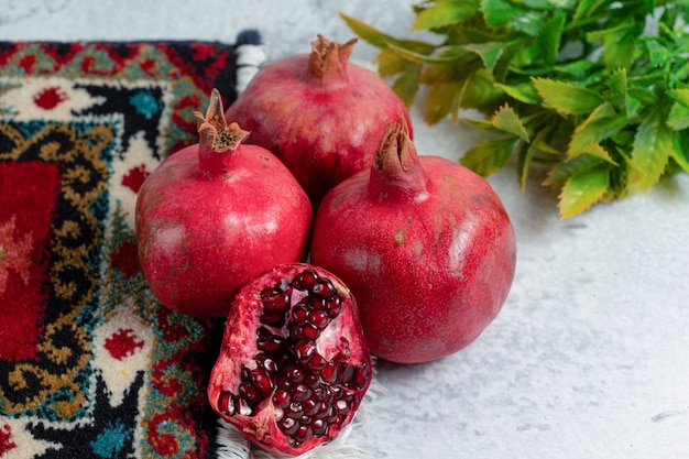 Frische organische Granatäpfel über altem traditionellem Teppich.