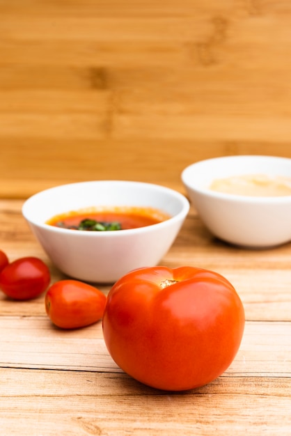 Kostenloses Foto frische organische tomaten und soße auf holztisch