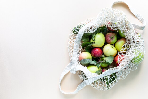 Frische Äpfel in einem Einkaufstaschennetz. Kein Abfall, kein Kunststoffkonzept. Eine gesunde Ernährung und Entgiftung. Herbsternte. Flache Lage, Draufsicht.