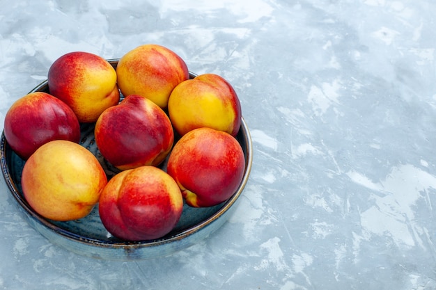 Frische Pfirsiche der Vorderansicht köstliche Sommerfrüchte auf hellweißem Schreibtisch