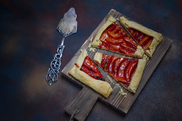 Frische Pflaume Galette Torte mit rohen Pflaumen auf Dunkelheit