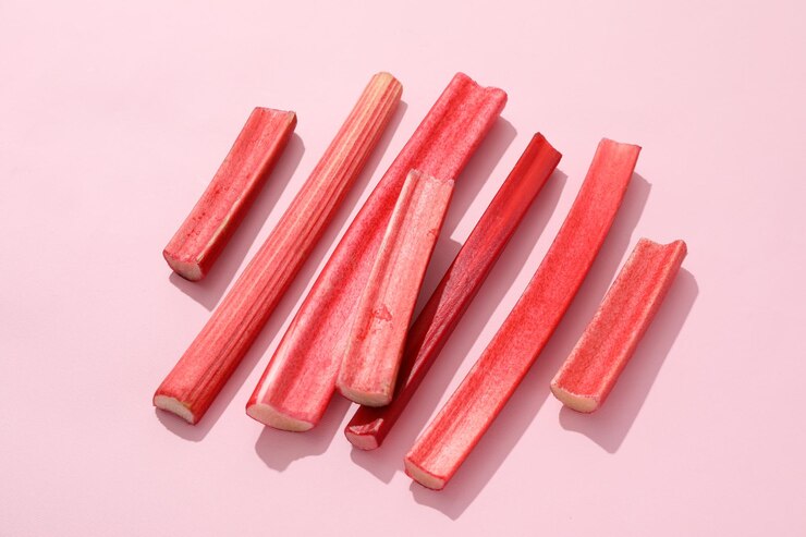 Kostenlose Foto frische rabarberstängel auf rosa hintergrund