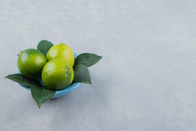 Frische reife Limetten in blauer Schüssel