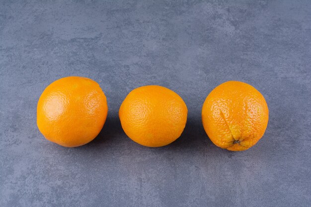 Frische reife Orangen auf der dunklen Oberfläche