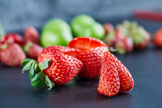 Frische rote Erdbeeren auf dunkler Oberfläche