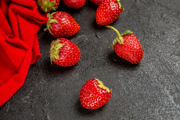 Frische rote Erdbeeren der Vorderansicht auf dem dunklen Hintergrund
