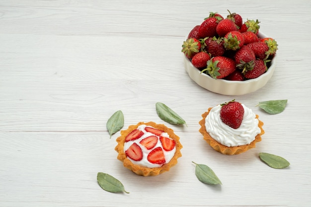 frische rote Erdbeeren weich und köstliche Beeren in weißen Teller mit Kuchen auf Licht