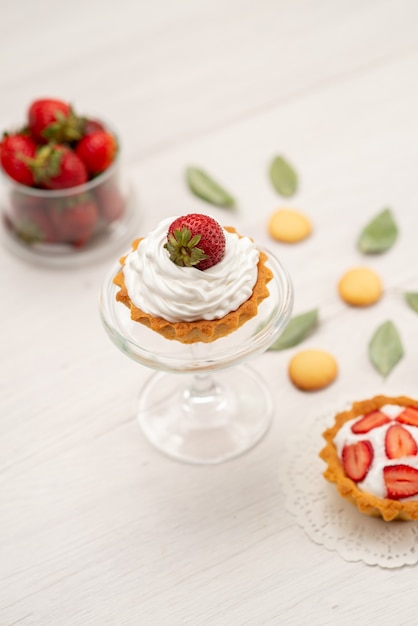 frische rote Erdbeeren weich und köstliche Beeren mit Kuchen und Keksen auf Licht