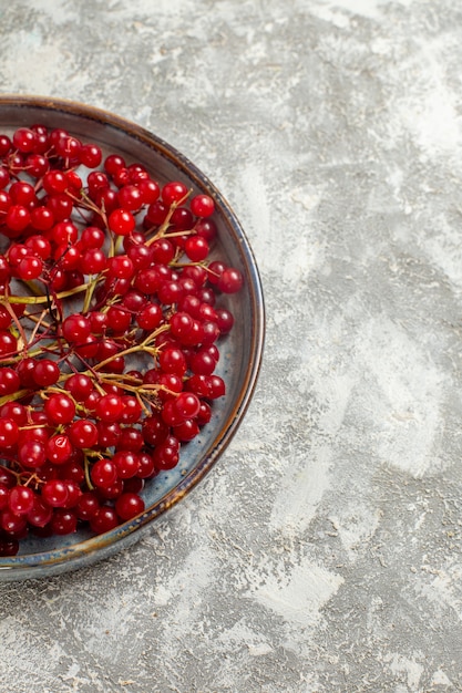 Frische rote Preiselbeeren der Vorderansicht in der Schale auf Wildrot der weißen Schreibtischbeerenfarbe