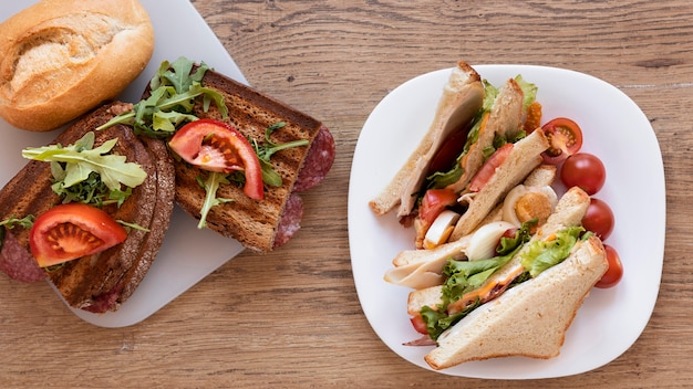 Frische Sandwiches Anordnung auf hölzernem Hintergrund