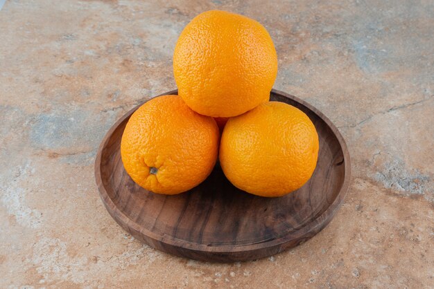 Frische saure Orangen auf Holzteller.