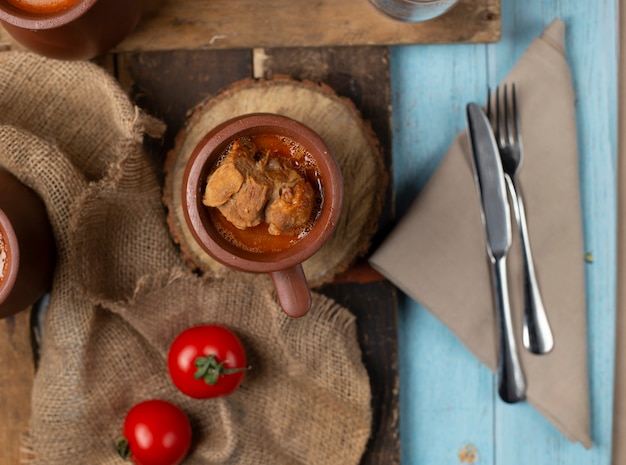 Frische Tomaten auf Sackleinen und kaukasischen Piti-Töpfen herum