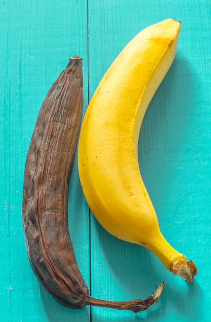 Frische und faule banane auf holzansicht von oben