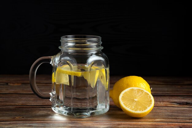 Frische Zitronen und eine Tasse reines Wasser