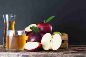 Kostenloses Foto frischer apfel in der holzkiste mit apfelsaft über schwarzem, frischem obst und saftprodukt