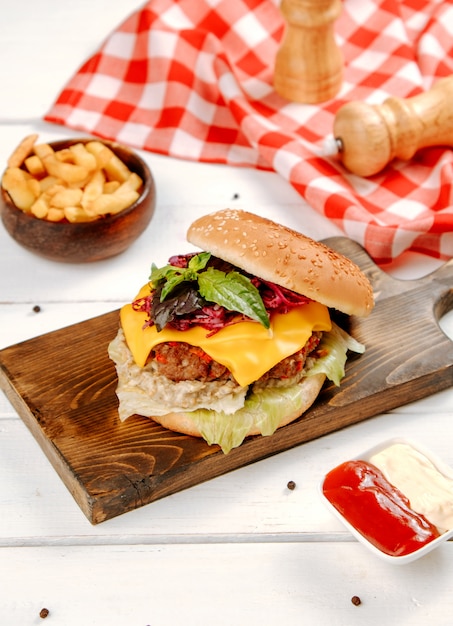 Frischer Cheeseburger mit Gemüse auf dem Tisch