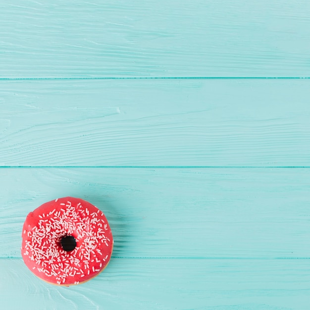 Frischer donut mit besprüht auf holztisch