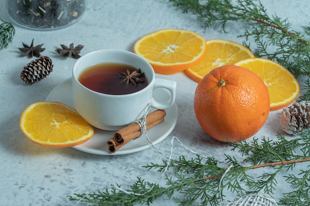 Frischer duftender Tee mit Bio-Orange auf Weihnachtstisch.