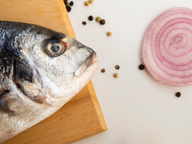 Frischer Fisch der Nahaufnahme nahe bei einer Zwiebel