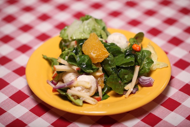 Frischer geschmackvoller salat in einer platte auf einer tischdecke