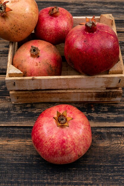 frischer Granatapfel in der Draufsicht des Korbes über Holztisch