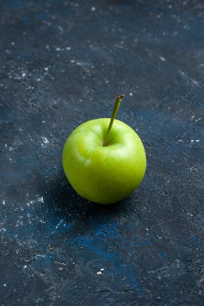 frischer grüner Apfel lokalisiert auf dunklem Schreibtisch