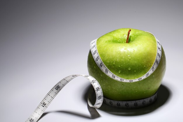 Frischer grüner Apfel mit Maßband