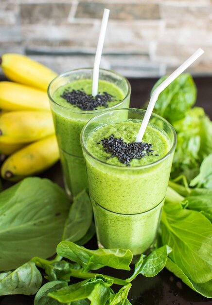 Frischer grüner Smoothie mit Banane und Spinat mit Herz aus Sesamsamen Liebe für ein gesundes Rohkostkonzept