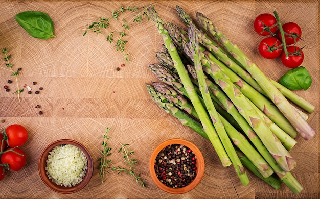 Frischer grüner Spargel auf einem rustikalen Holztisch mit Kopienraum. Draufsicht