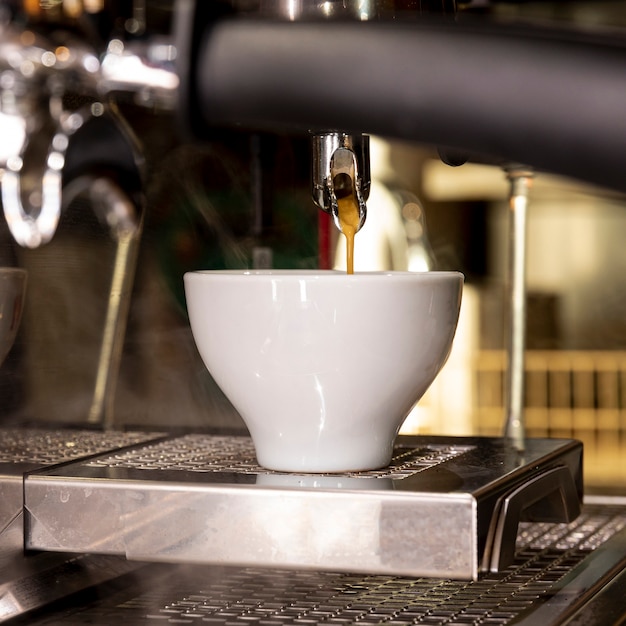 Kostenloses Foto frischer kaffee der nahaufnahme, der in schale gießt