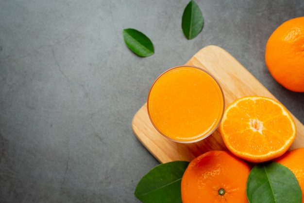 Frischer Orangensaft im Glas auf dunklem Hintergrund