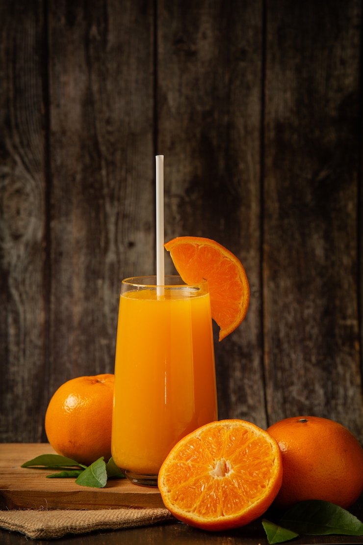 Kostenlose Foto frischer orangensaft in einem glas und frische orange