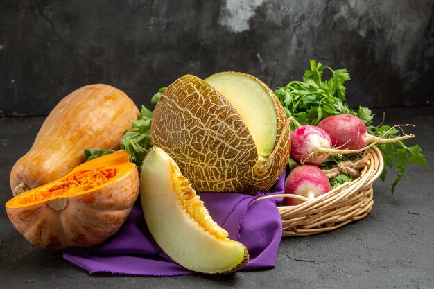 Frischer Rettich der Vorderansicht mit Kürbis und Melone auf frischem reifen Salat des dunklen Tisches