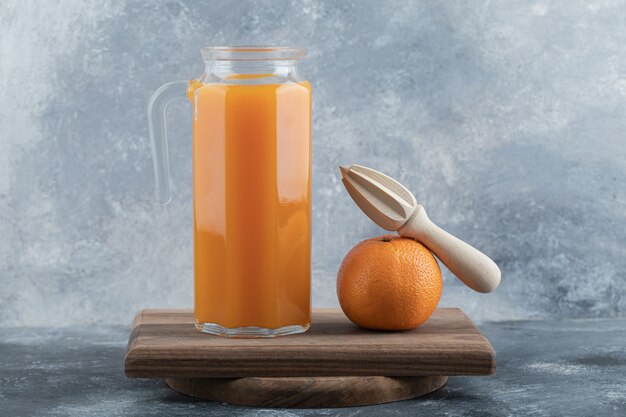 Frischer Saft und Orange mit Reibahle auf Holzbrett.