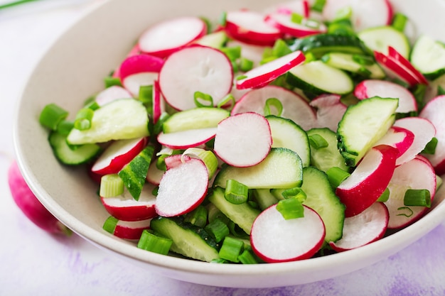 Frischer Salat aus Gurken, Radieschen und Frühlingszwiebeln.
