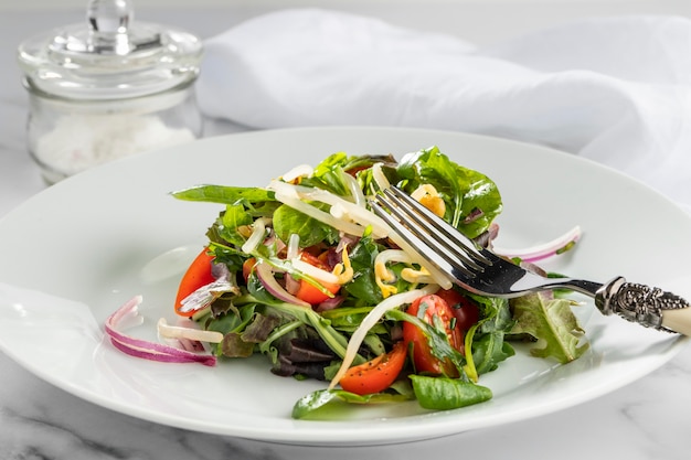 Kostenloses Foto frischer salat der vorderansicht auf weißem teller