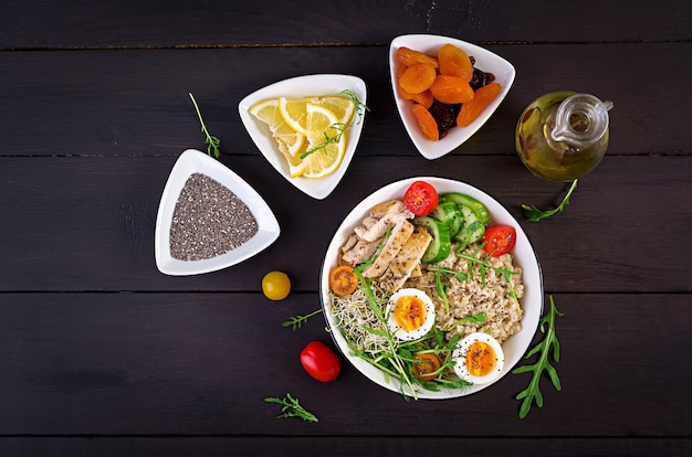 Frischer Salat. Frühstücksschüssel mit Haferflocken, Hähnchenfilet, Tomate, Salat, Microgreens und gekochtem Ei. Gesundes Essen. Vegetarische Buddha-Schüssel.